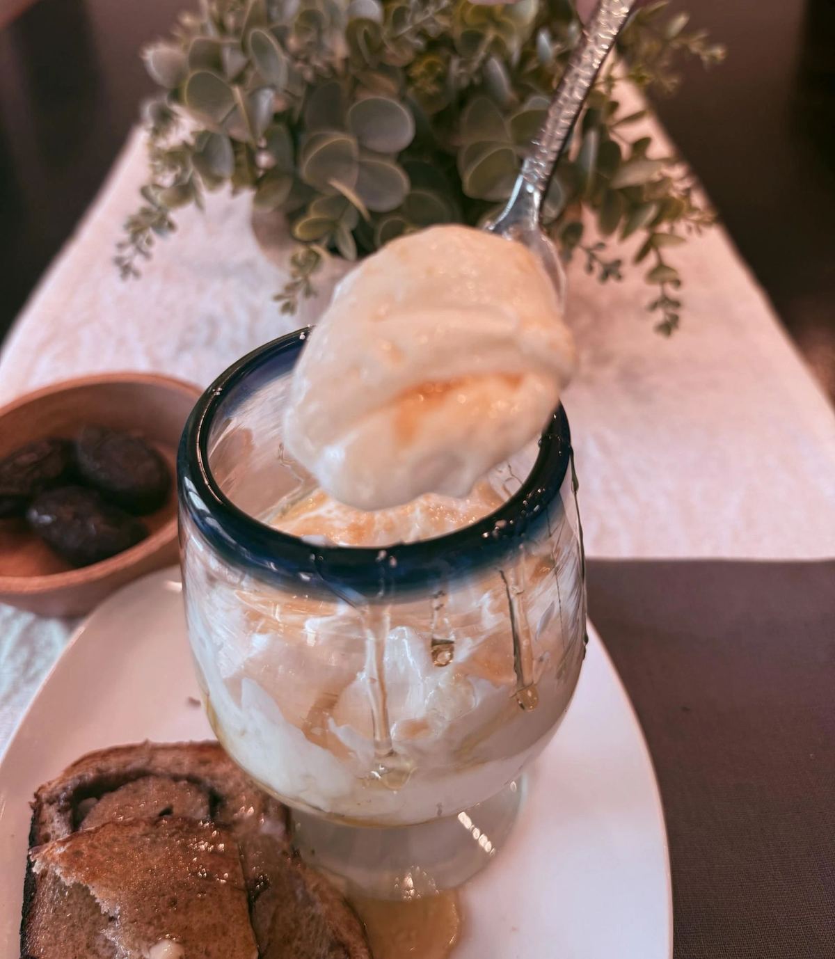 Skyr smoothie in a glass beside a jar of plain strained skyr, compared with Greek yogurt